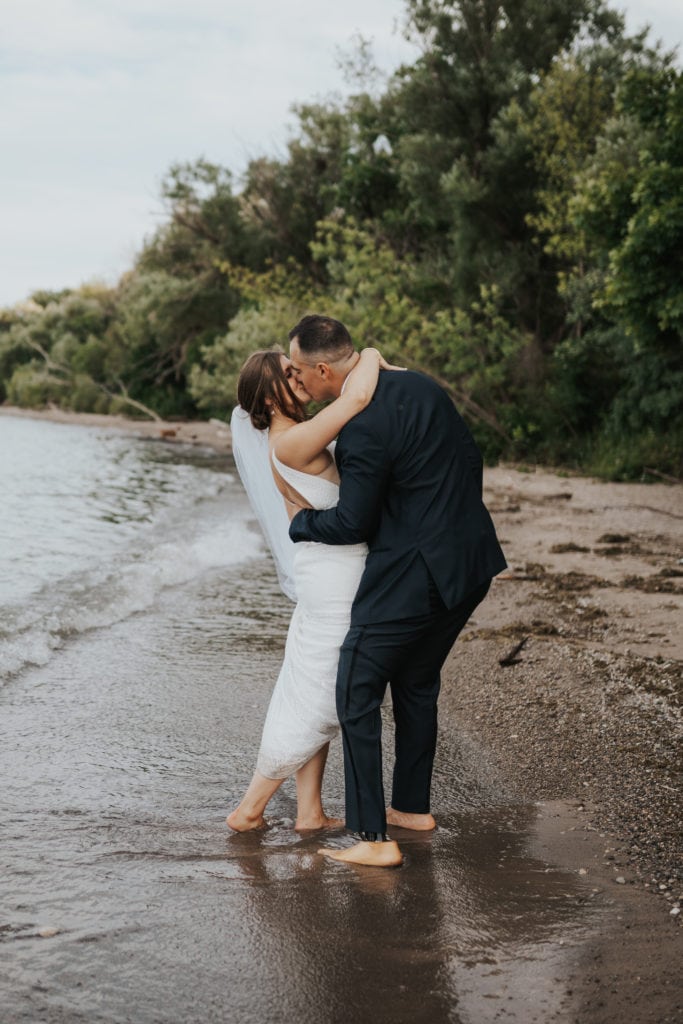 Bride + groom kissing on a beach in New Zealand