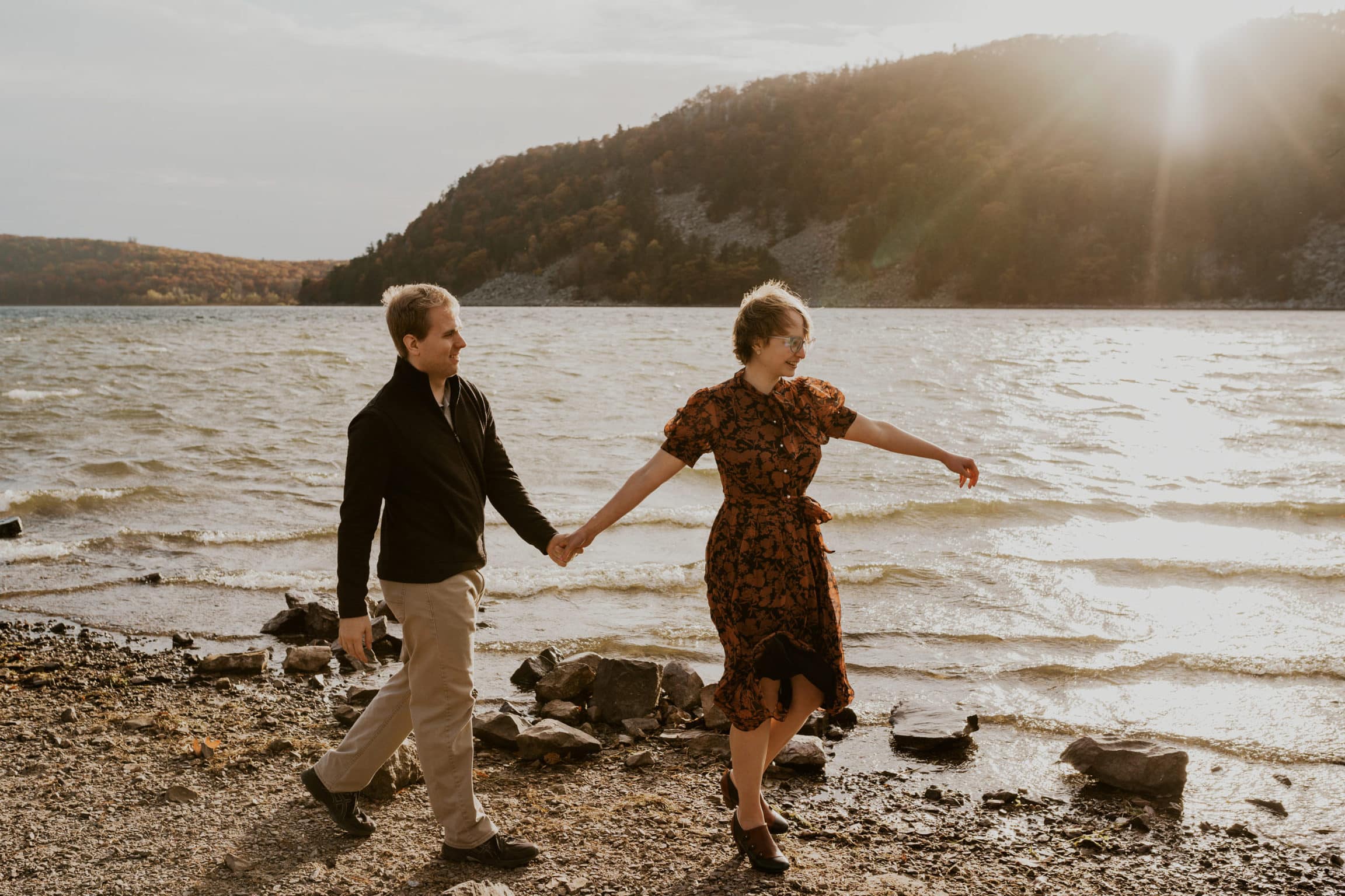 Couple holding hands and walking the beach at Devils Lake