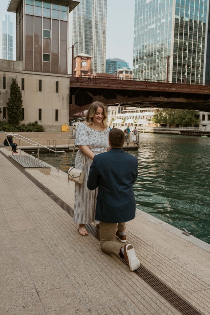 Boyfriend on one knee proposing on the chicago riverwalk