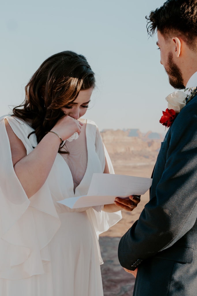 What to do after you elope: Bride tearfully reading letters from family during their elopement ceremony