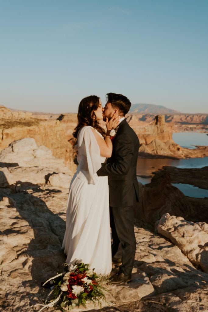 Bride and groom first kiss at their elopement ceremony in Lake Powell, Utah