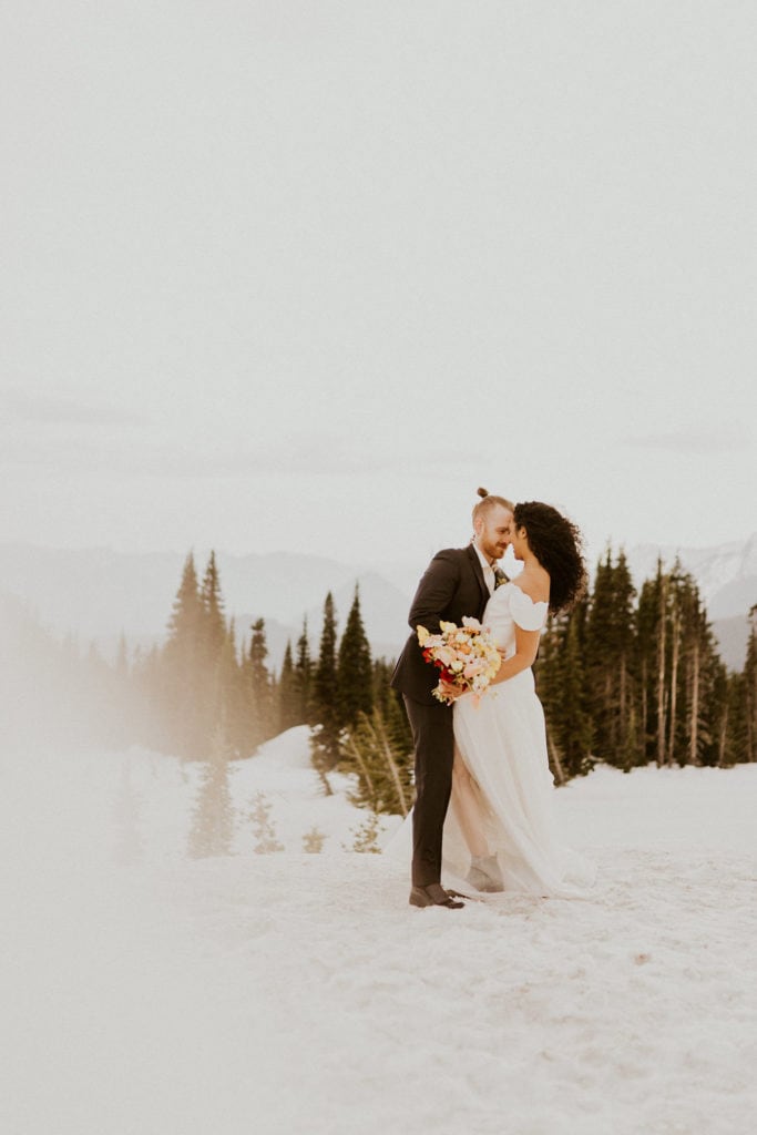 Bride and Groom overlooking Mt Rainier during their snowy winter elopement